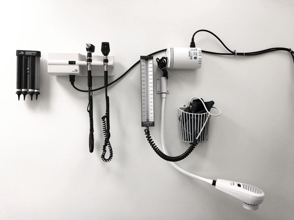 Blood pressure instruments on the wall of a doctor's office.